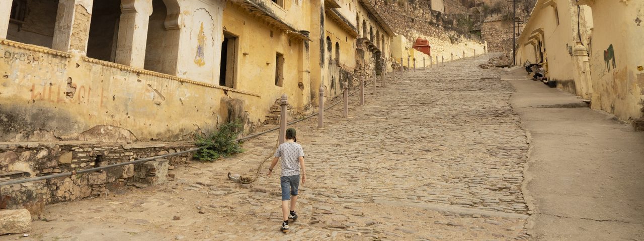 Boy walking on quiet street in India