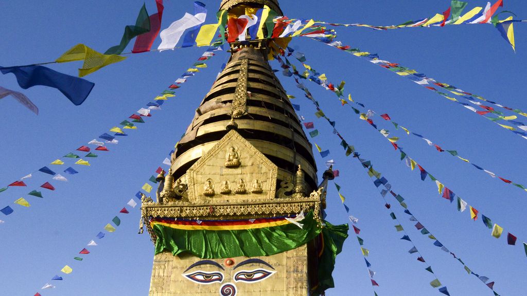 Prayer flags fluttering from a temple spire