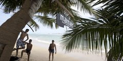a group of men playing on a beach