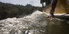 a close-up of a hand reaching out to the water