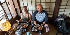 a man and woman sitting at a table with food