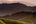 a green hills with trees in the background