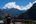 a woman sitting on a balcony overlooking a mountain range
