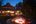 Couple sat at fire pit at night at Karnali Lodge