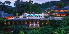 a building with a pool and trees
