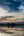 a body of water with clouds and trees