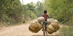 Boy on a laden bike in Cambodia