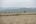 a field with houses in the background