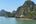 a body of water with a rocky hill and a boat