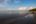 a beach with waves and clouds