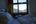 a bed with pillows and a window