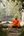 a monk sitting on a stone path in the woods