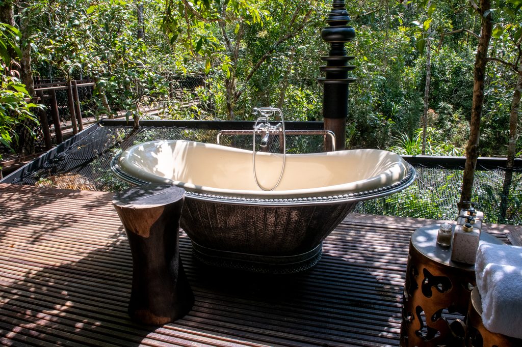 a bathtub outside with trees in the background