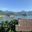 a house with a thatched roof surrounded by water and mountains
