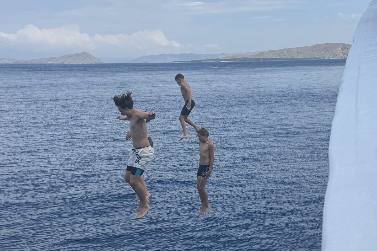 Boys jumping from a boat in Indonesia