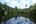 a body of water with trees and clouds in the sky