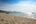 a sandy beach with a boat on the water
