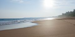 a sandy beach with waves crashing on the shore