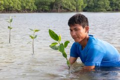 a man in the water holding a plant