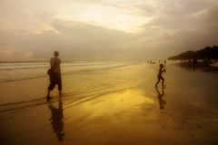 a woman and child walking on a beach