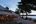 a beach with a thatched roof and trees