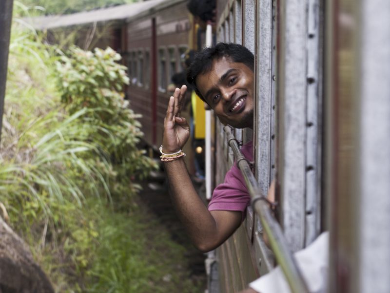 Man waving from train in Sri Lanka