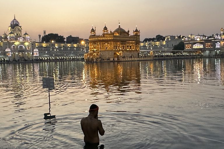a man standing in water with a building in the background