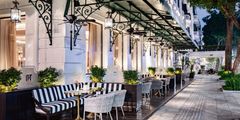 a sidewalk with tables and chairs