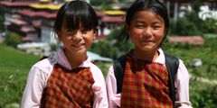 a pair of young girls wearing school uniforms