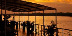 a deck with a covered area and a body of water