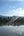 a body of water with trees and mountains in the background