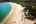 a beach with umbrellas and chairs and trees