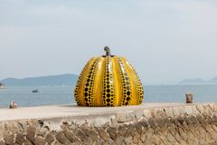 a yellow and black pumpkin on a stone wall