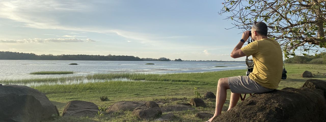 Man sitting on rock overlooking Wasgamuwa National Park