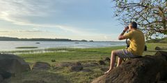 Man sitting on rock overlooking Wasgamuwa National Park