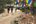 people walking on a dirt path with colorful flags