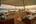 a deck with a large white tent and chairs and tables