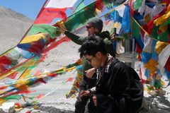a group of people standing outside with colorful flags