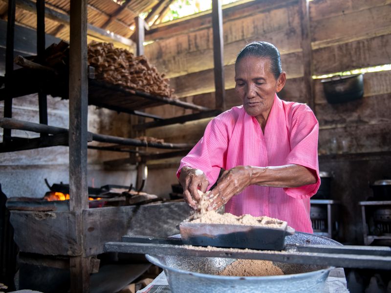 Woman cooking in wooden hut Indonesia