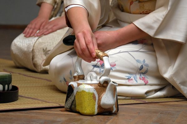 Lady dressed in a kimono pouring a teapot