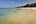 a sandy beach with trees in the background