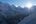 a sun shining through the mountains